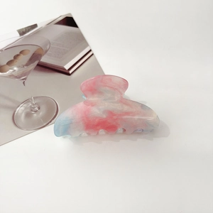 Detail of pink and blue gradient marble hair claw clip with shimmering glitter finish