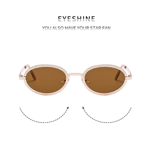 Detail view of oval metal sunglasses with hammered rose gold finish and brown lenses