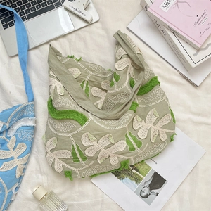 Dettagli di ricami e frange su questa borsa a tracolla in tela verde oliva a fiori