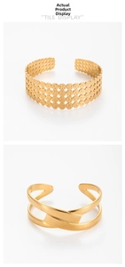 Detail view of two gold-plated cuff bracelets with hammered texture and hollow patterns