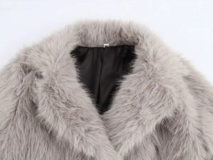 Detail view of the grey faux fur coat collar showing soft plush texture and black lining