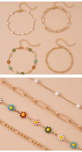 Dettaglio macro di un set di 4 gioielli dorati con margherite e perle finte