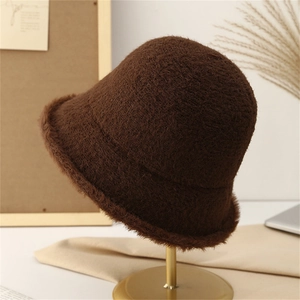 Detail of dark brown plush knit bucket hat showing fuzzy texture on golden stand