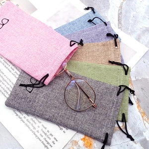 Close-up of colorful linen drawstring pouches for sunglasses with a textured fabric finish