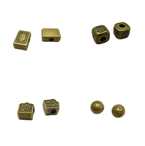Detailed macro of vintage bronze spacer beads with engraved Chinese characters for DIY jewelry