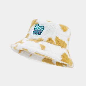 Close-up of white plush bucket hat with brown cow print and Chill OUT embroidery patch