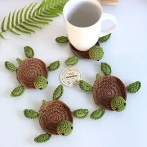 Detail of four handmade crochet turtle coasters with intricate green and brown stitch patterns