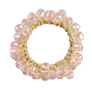 Detail of pink crystal beads woven with gold wire on a fashionable hair elastic
