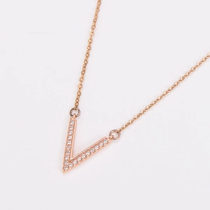 Macro view of rose gold V-shaped pendant necklace with sparkling micro-inlaid stones
