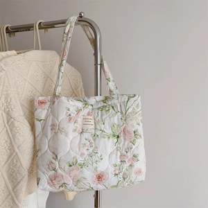 Close-up of quilted floral cotton tote bag featuring delicate pink rose patterns