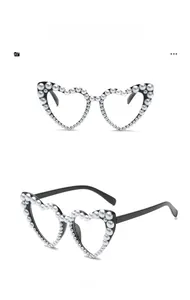 Detail view showing heart-shaped black sunglasses with white pearl embellishments