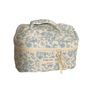 Floral quilted cotton makeup bag with blue flowers and ribbon zippers on white background