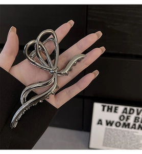 Detailed close-up of a large chrome silver butterfly hair claw clip with mirror finish