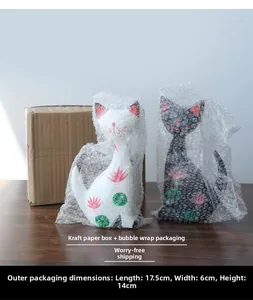 Detailed packaging view of creative cat figurines with pink lotus motifs in protective boxes