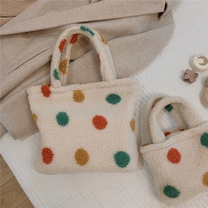 Detail of plush polka dot tote bag set in cream faux fur with colorful fuzzy accents
