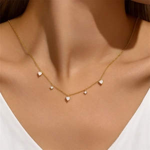 Detail of s925 silver gold necklace featuring five heart pendants with sparkling zircons