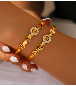 Macro shot of gold-plated Tree of Life bangle featuring hollow design and sparkling rhinestones