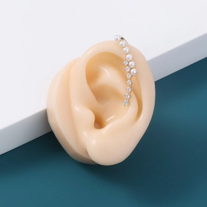 Golden star ear cuff with pearls and rhinestones shown on a model ear