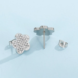 Macro detail of silver flower stud earrings with shimmering white crystals and metal backs