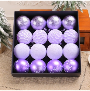 Macro view of 16-pack purple Christmas baubles with glitter and snowflake patterns in box