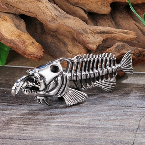 Close-up of vintage silver fish bone pendant necklace on a natural wood surface