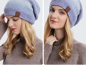 Détail du bonnet en maille dégradé bleu-violet avec écusson en cuir sport