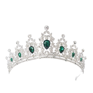 Detailed close-up of a silver tiara featuring sparkling rhinestones and green emerald gems