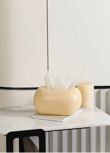 Détail de la boîte à mouchoirs crème en forme de nuage sur table en marbre moderne