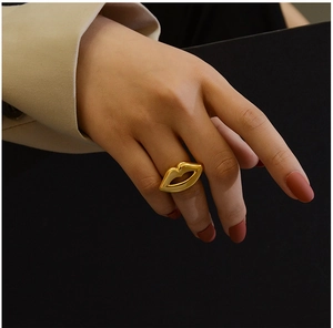 Close-up of a 18K gold plated titanium ring featuring a unique lip design on a model's hand