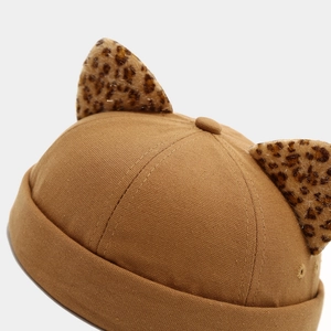 Close-up of leopard print cat ears on a brown cotton sailor cap with neat stitching