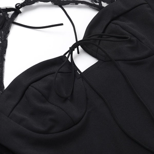 Dettaglio ravvicinato della scollatura a corsetto in pizzo nero con ricami e laccetti