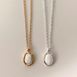 Close-up of elegant gold and silver oval opal necklaces with minimalist O-chain links