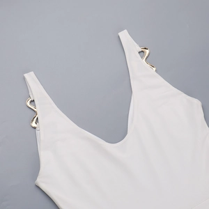 Detail of white ribbed knit fabric with wavy gold metal decorative buckle on shoulder