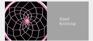 Detail of pink hand-knitted dreamcatcher net featuring a central bead and artisan craft