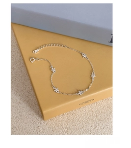 Macro shot of S925 sterling silver chain bracelet with five delicate flower charms