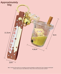 Detailed view of bubble tea keychain with floating bear doll and golden bell charm