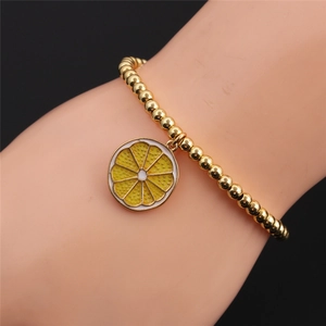Gold plated beaded stretch bracelet featuring an orange enamel fruit slice charm for women