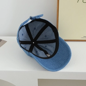 Detailed inner view of blue denim baseball cap showing reinforced seams and buckle strap