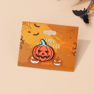 Detailed view of an orange pumpkin enamel brooch with Happy Halloween festive card packaging