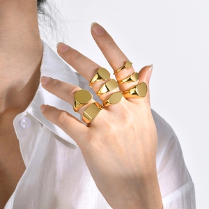 Polished gold geometric signet rings showing mirror finish and minimalist style