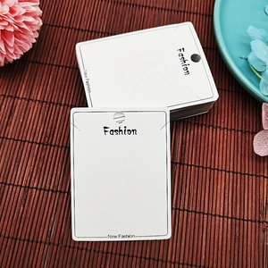 Detail of white PVC jewelry display card with hanging hole for earrings and fashion text