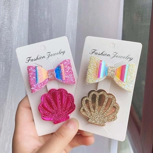 Close-up of glittery bow and shell hair clips for girls in pink and white set