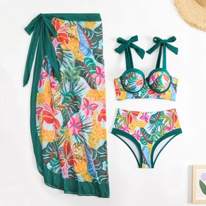 Flat lay of tropical floral bikini set with high-waist bottoms and mesh sarong wrap