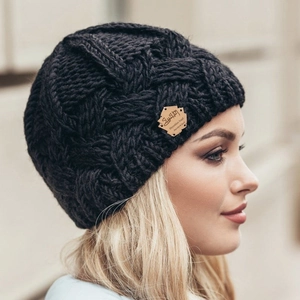 Chunky knit beanie for winter featuring a black diamond pattern and leather patch detail