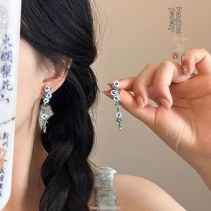 Gros plan détaillé de boucles d'oreilles à fleurs avec perles bleu-vert sur un mannequin