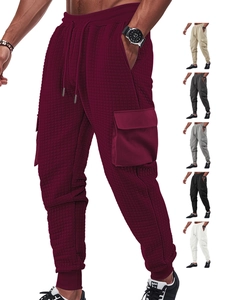 Detail of men's cargo joggers in waffle texture with drawstring waist and side pockets