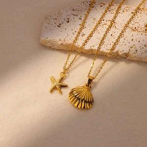 Gold stainless steel ocean necklace set featuring starfish and scallop shell pendants