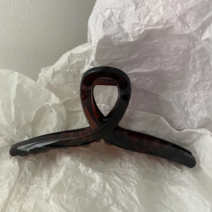 Detail of tortoiseshell ribbon hair claw clip in dark brown with metal spring