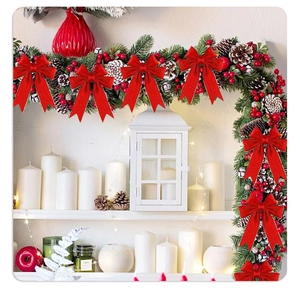 Detail of red velvet Christmas bow with gold wire edges on a festive fireplace mantel