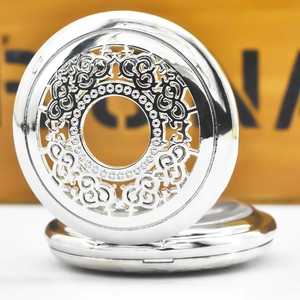 Macro shot of vintage silver hollow carved pocket watch case on a wooden surface